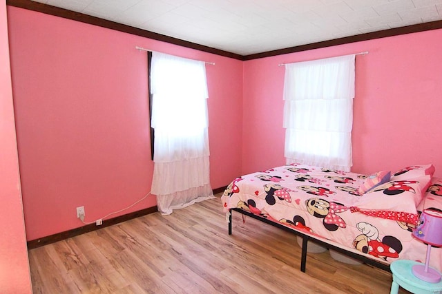 bedroom with multiple windows and wood-type flooring