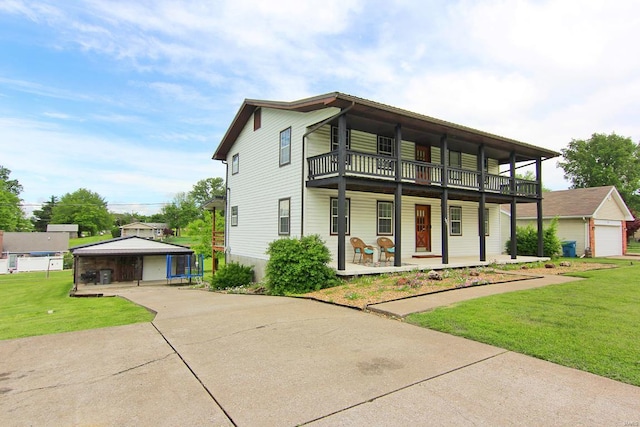 view of front facade featuring an outdoor structure, a front yard, a balcony, and a garage