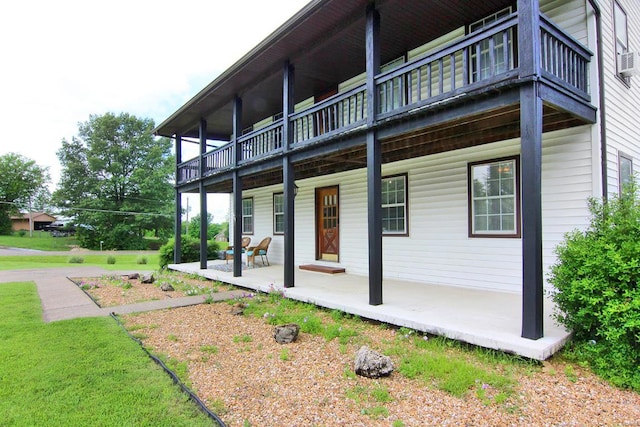 rear view of property with a yard and a balcony