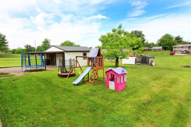 view of play area featuring a trampoline, an outdoor structure, and a lawn