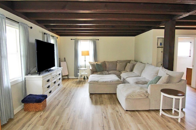 living room with beam ceiling, baseboards, and light wood-style floors