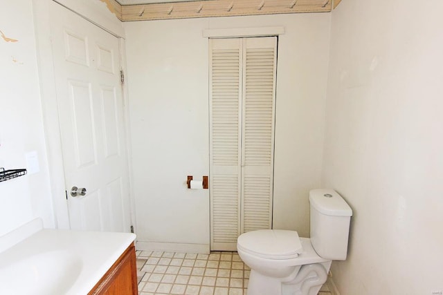 bathroom featuring toilet, vanity, and baseboards