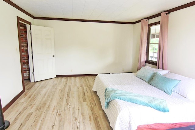 bedroom with crown molding, baseboards, and wood finished floors