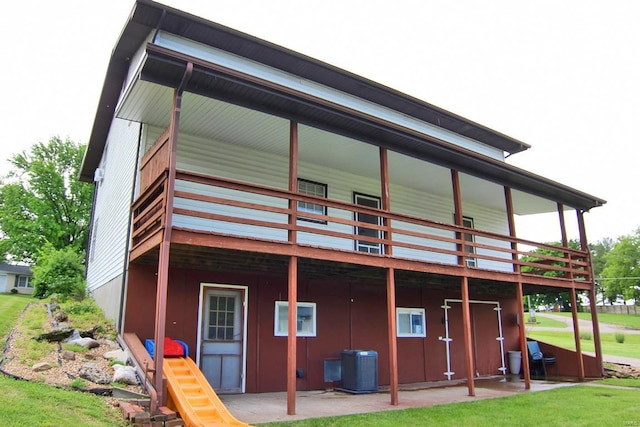 rear view of property featuring central air condition unit and a yard