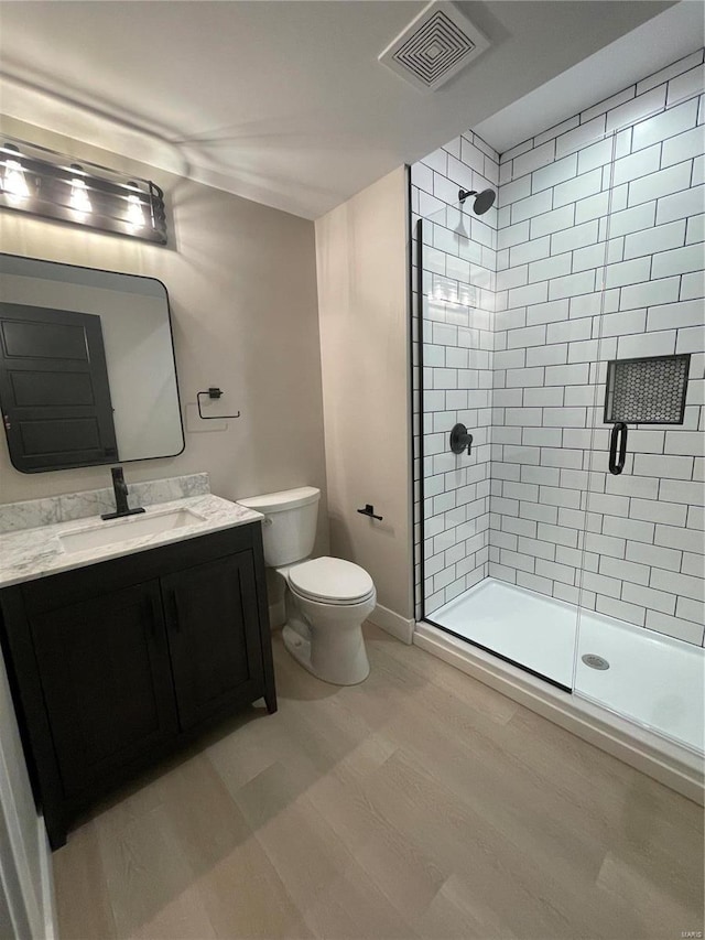 bathroom with vanity, toilet, and a shower with shower door