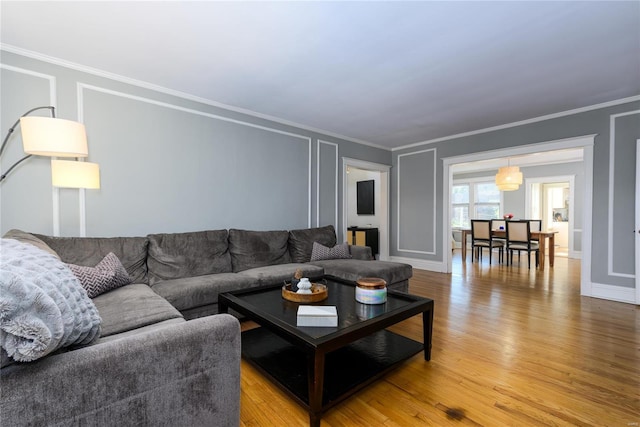 living room with crown molding and light hardwood / wood-style floors