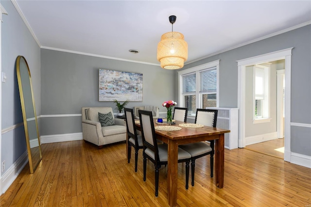 dining area featuring light hardwood / wood-style floors and crown molding