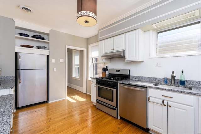 kitchen featuring appliances with stainless steel finishes, light hardwood / wood-style flooring, white cabinetry, and sink