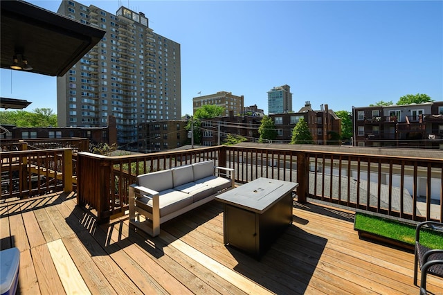 wooden terrace with an outdoor living space with a fire pit