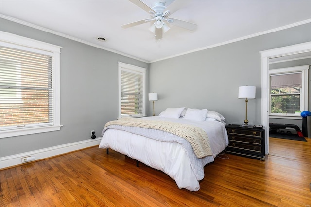 bedroom with ceiling fan, ornamental molding, and hardwood / wood-style floors