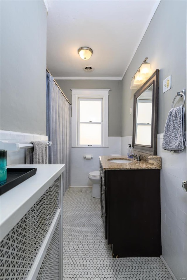 bathroom with toilet, crown molding, plenty of natural light, and vanity