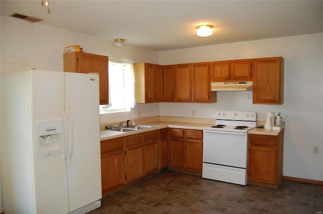 kitchen featuring sink, dark tile flooring, and white appliances