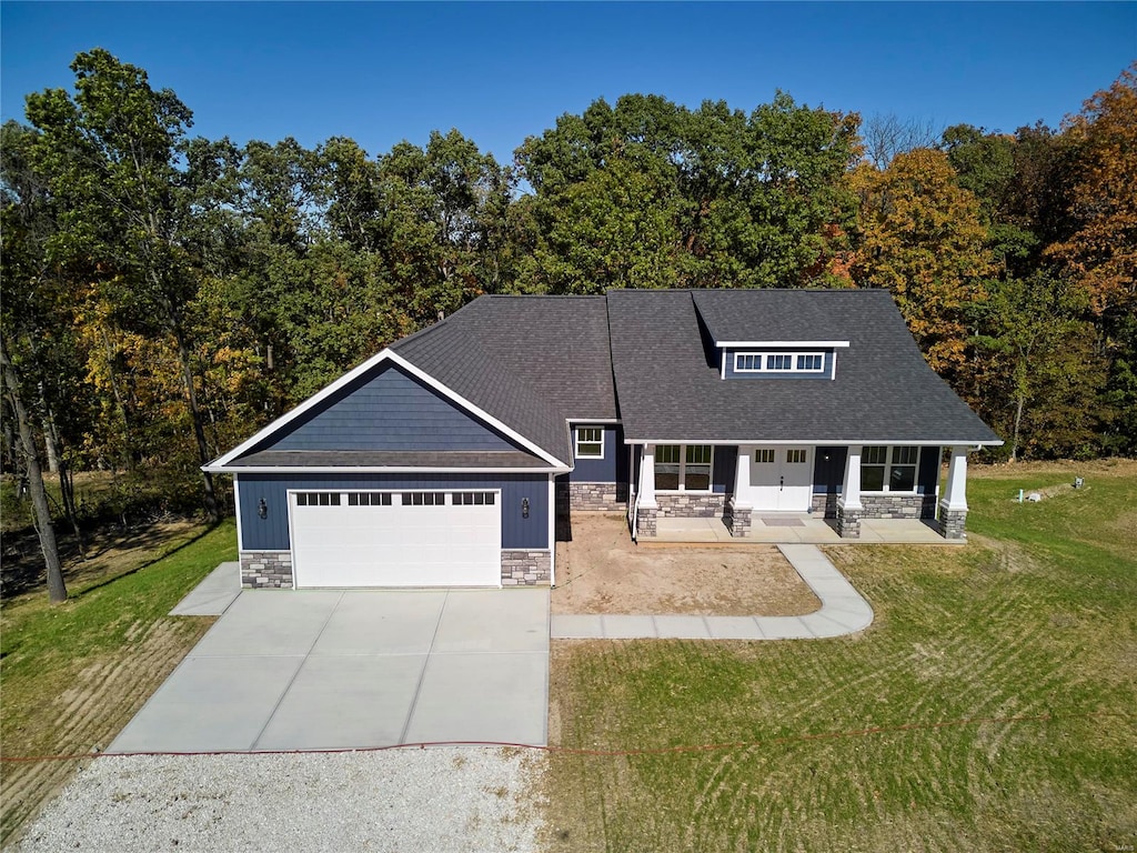 craftsman house with a garage, a front yard, and covered porch