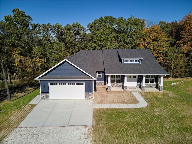 craftsman house with a garage, a front yard, and covered porch