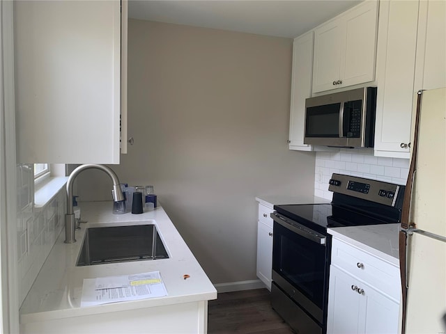 kitchen with sink, white cabinets, dark hardwood / wood-style floors, and appliances with stainless steel finishes