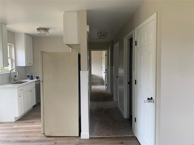 kitchen featuring white fridge, light hardwood / wood-style flooring, white cabinetry, and sink