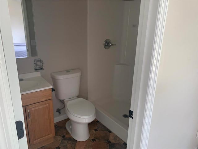 bathroom featuring vanity, toilet, and walk in shower