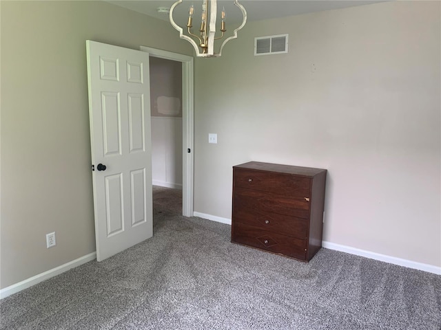 spare room with carpet floors and a chandelier