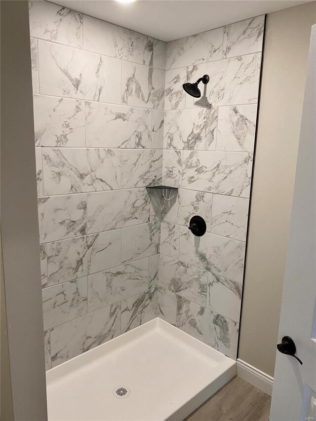 bathroom featuring hardwood / wood-style flooring and tiled shower