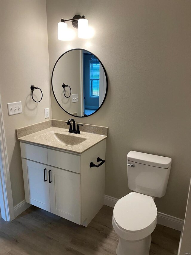 bathroom with vanity, toilet, and wood-type flooring