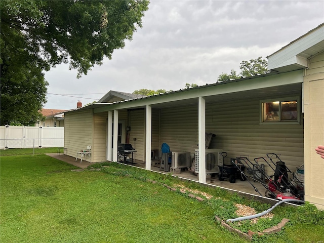 back of house with a lawn and a patio