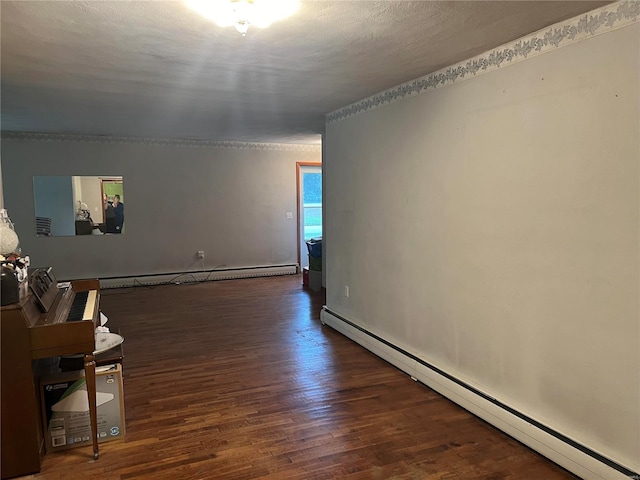 spare room featuring a textured ceiling, a baseboard radiator, and dark wood-type flooring