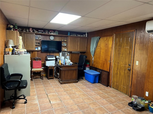 office space with a paneled ceiling, an AC wall unit, and wood walls