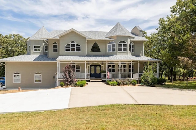 victorian-style house featuring a front lawn and a porch