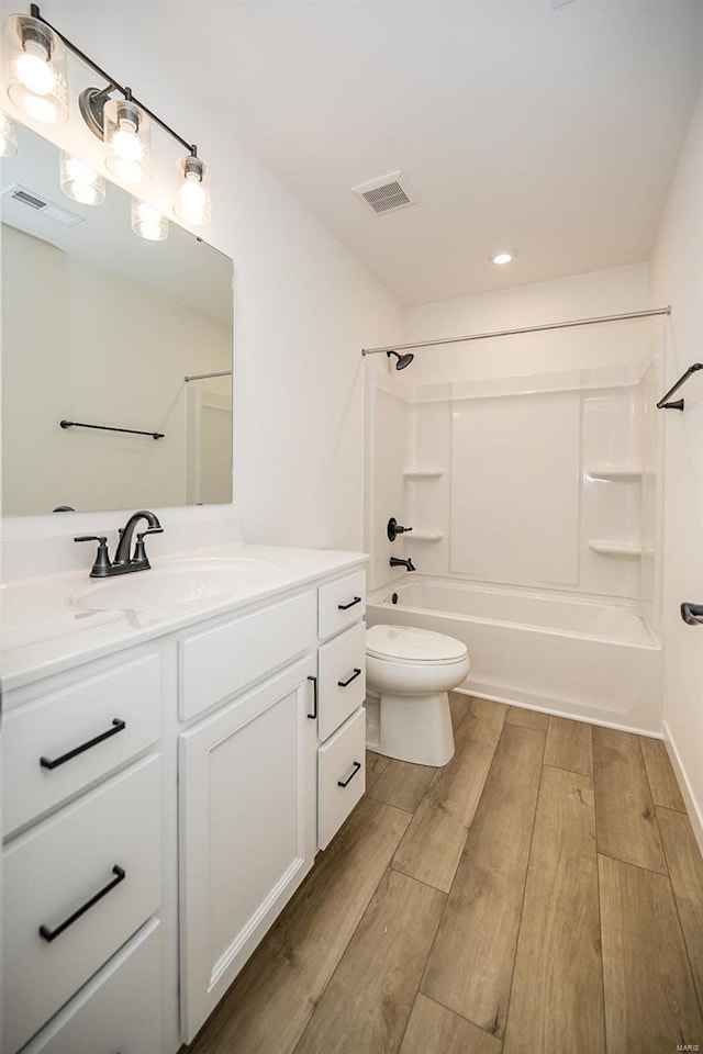 full bathroom featuring shower / bath combination, vanity, wood-type flooring, and toilet