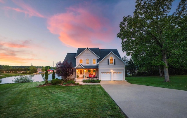 view of front of home featuring a water view, a garage, and a lawn