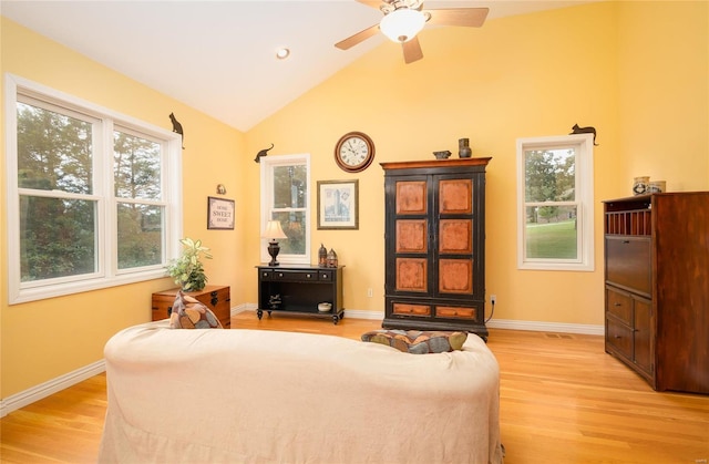 living area featuring ceiling fan, plenty of natural light, light wood-type flooring, and lofted ceiling