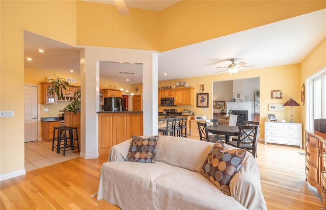 living room featuring ceiling fan and light hardwood / wood-style flooring