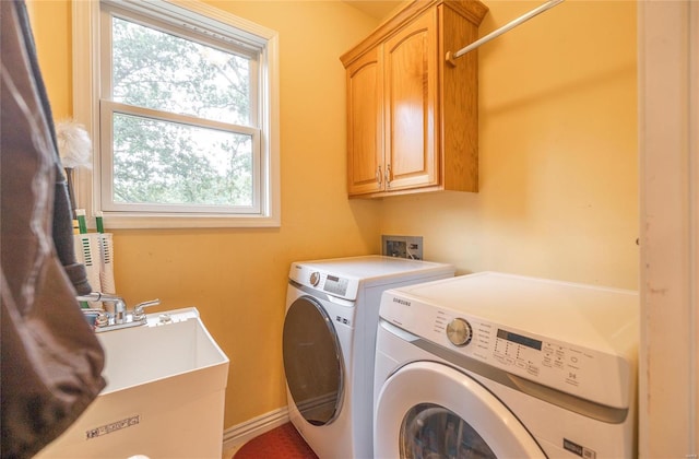 laundry area with washer and dryer, cabinets, and sink