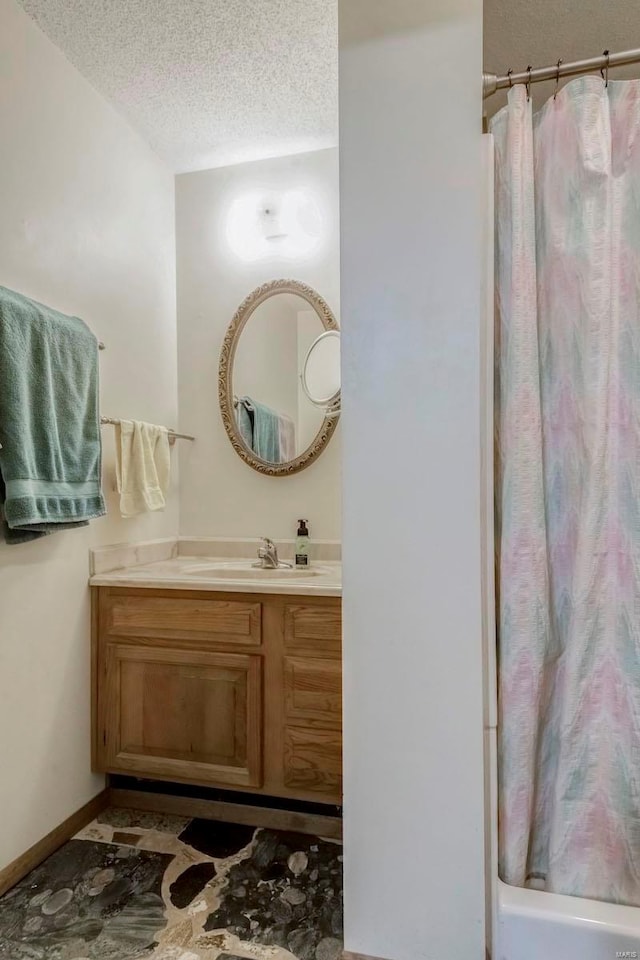 bathroom with a textured ceiling and vanity