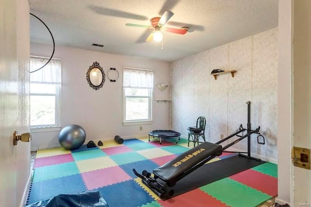 workout area with a textured ceiling and ceiling fan