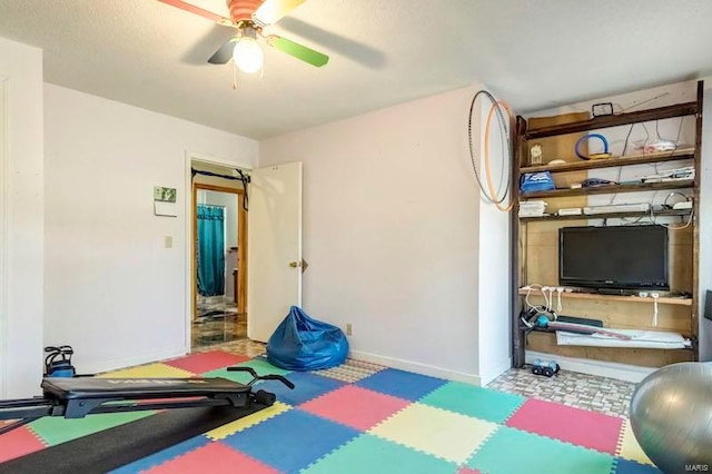 exercise room with ceiling fan