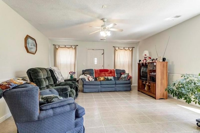 living room with tile floors, a textured ceiling, and ceiling fan