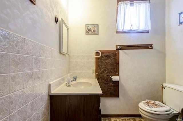 bathroom with vanity with extensive cabinet space, backsplash, toilet, and tile walls