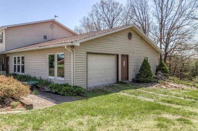 view of home's exterior with a garage and a lawn