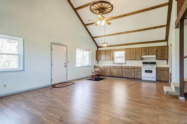 unfurnished living room with high vaulted ceiling, hardwood / wood-style flooring, sink, and ceiling fan