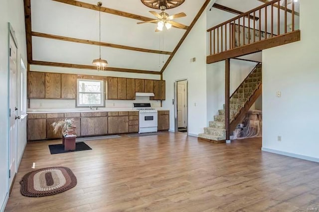 kitchen featuring ceiling fan, a high ceiling, hardwood / wood-style flooring, and white stove