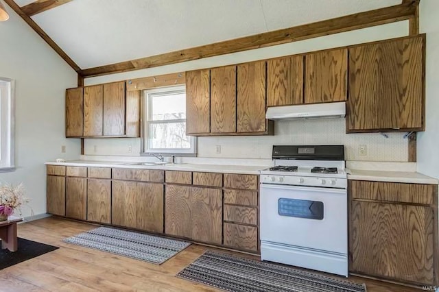 kitchen with vaulted ceiling, sink, white range with gas cooktop, and light hardwood / wood-style flooring