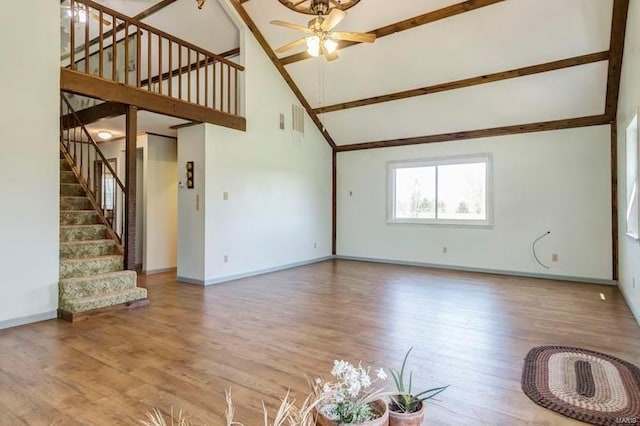 unfurnished living room with high vaulted ceiling, wood-type flooring, and ceiling fan