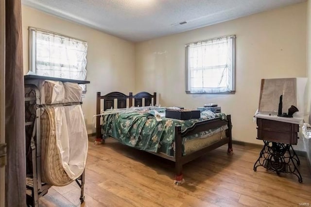 bedroom featuring a textured ceiling and hardwood / wood-style flooring