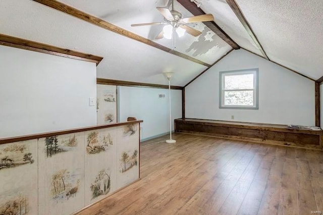 additional living space featuring ceiling fan, a textured ceiling, lofted ceiling, and wood-type flooring