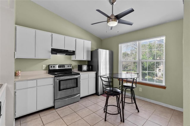 kitchen with ceiling fan, stainless steel appliances, white cabinets, lofted ceiling, and light tile patterned flooring