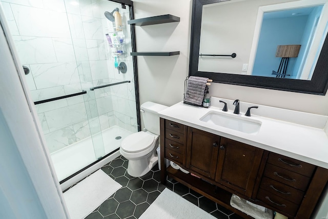 bathroom with tile patterned flooring, vanity, toilet, and walk in shower