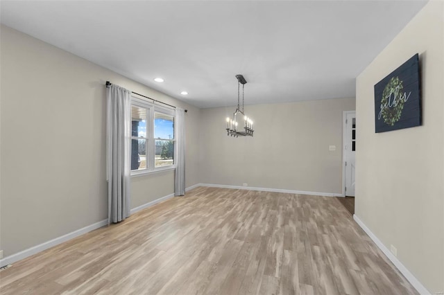 unfurnished dining area featuring a notable chandelier and light hardwood / wood-style flooring