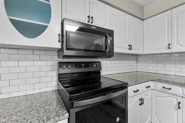 kitchen with white cabinetry, light stone countertops, decorative backsplash, and stainless steel range with electric stovetop