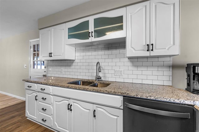 kitchen with black dishwasher, sink, white cabinets, and dark stone counters